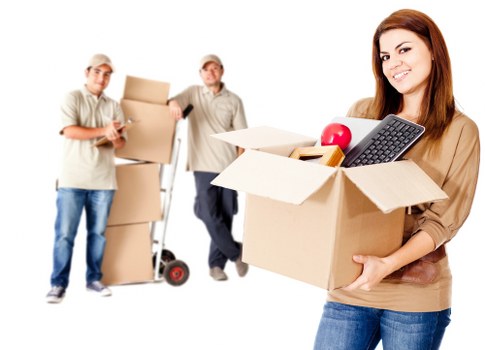 Professional movers handling desks and equipment during an office move